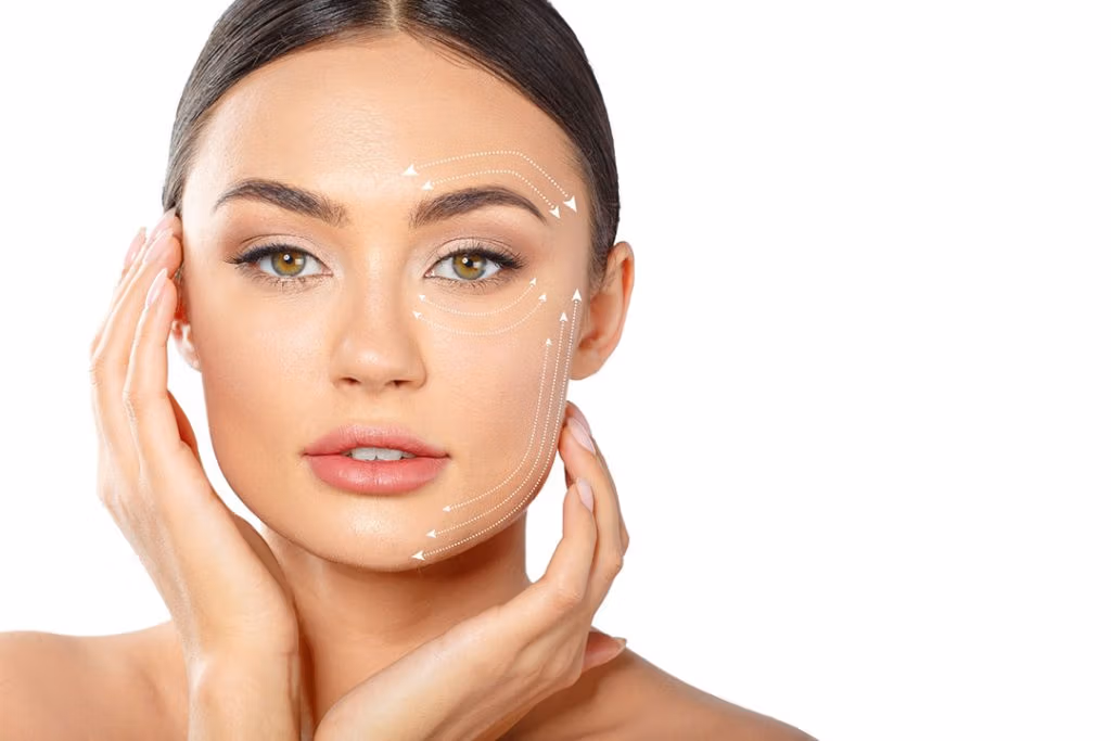 Een vrouw laat de gezichtsgebieden zien die met een facelift behandeld kunnen worden. Deze gebieden zijn aangegeven met pijlen op een witte achtergrond.