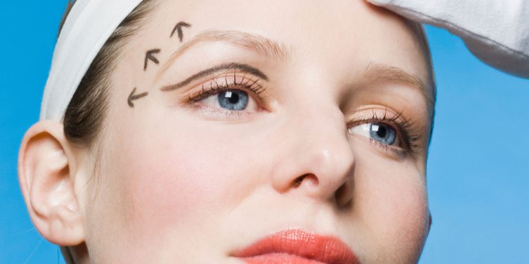 Primer plano del rostro de una mujer con flechas que indican la dirección de un levantamiento de cejas, resaltando la zona sobre los ojos. Tiene ojos azules y lleva una diadema blanca.