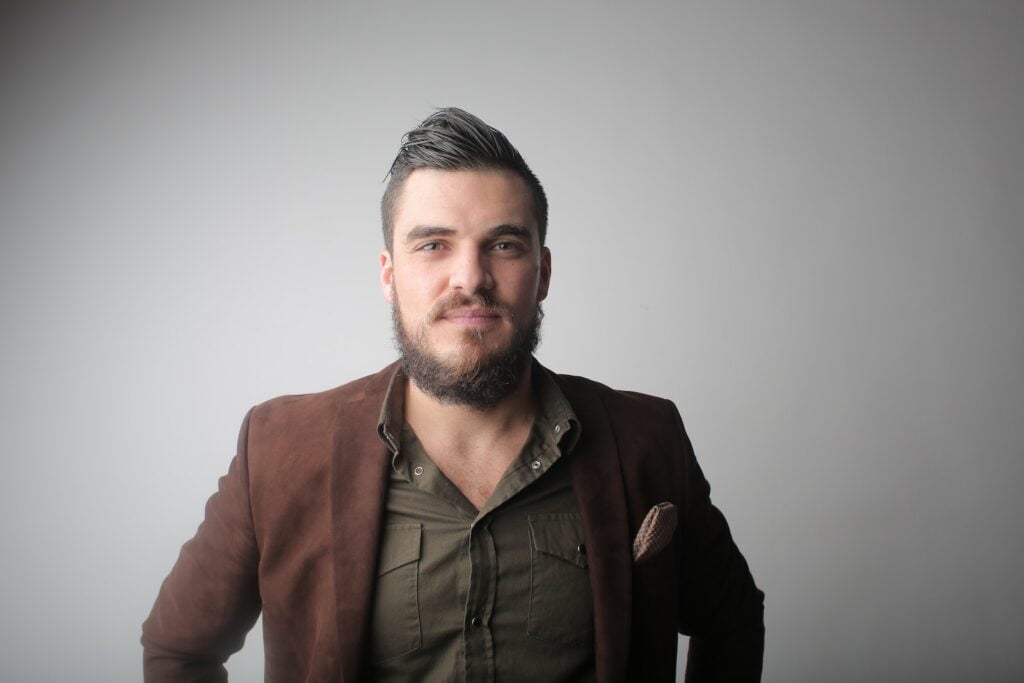 Foto de un hombre serio con abrigo marrón
