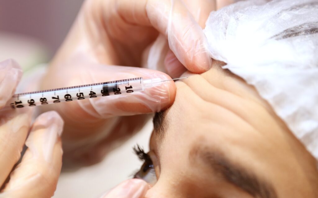 a woman getting her eyebrows examined by a doctor, botox