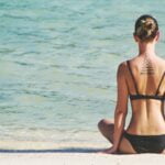 denize bakan yoga pozisyonunda bikini giyen kadın