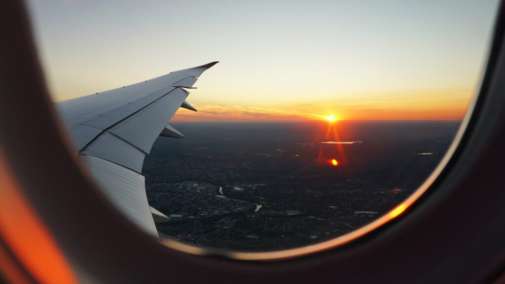 Flugzeugfensterblick auf den Himmel während der goldenen Stunde