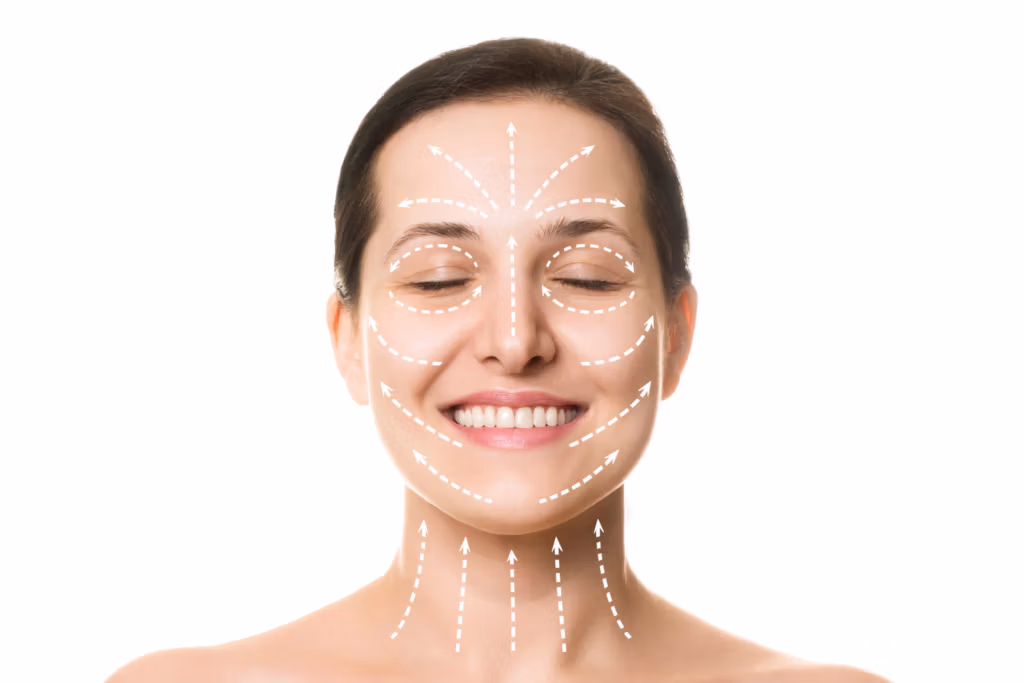 Una mujer con los ojos cerrados y una leve sonrisa, en cuyo rostro se aprecian zonas resaltadas con líneas discontinuas y flechas, que indican áreas para análisis facial o tratamiento cosmético.