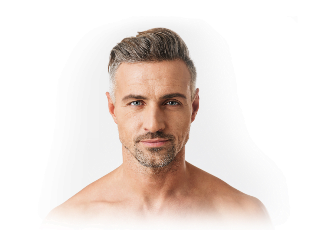 Gros plan d'un homme d'âge mûr aux cheveux gris courts et à la barbe soignée. Son expression à la fois sérieuse et calme est à la fois posée et il regarde droit vers l'objectif. L'arrière-plan blanc uni focalise entièrement son regard sur son visage.