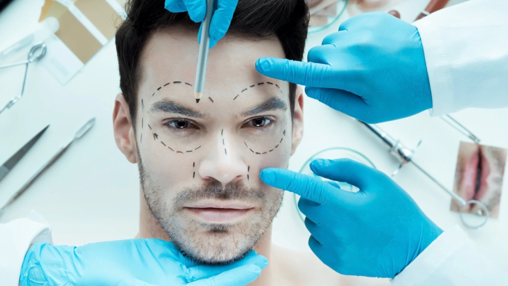 Yüzünde cerrahi işaretler bulunan, tıbbi bir masada yatan bir adam, mavi eldivenli ve cerrahi aletler tutan sağlık görevlileri tarafından çevrelenmiş.