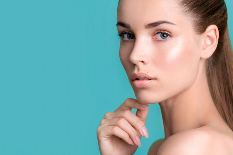 Un retrato en primer plano de una mujer de piel suave y expresión contemplativa, sobre un fondo verde azulado.