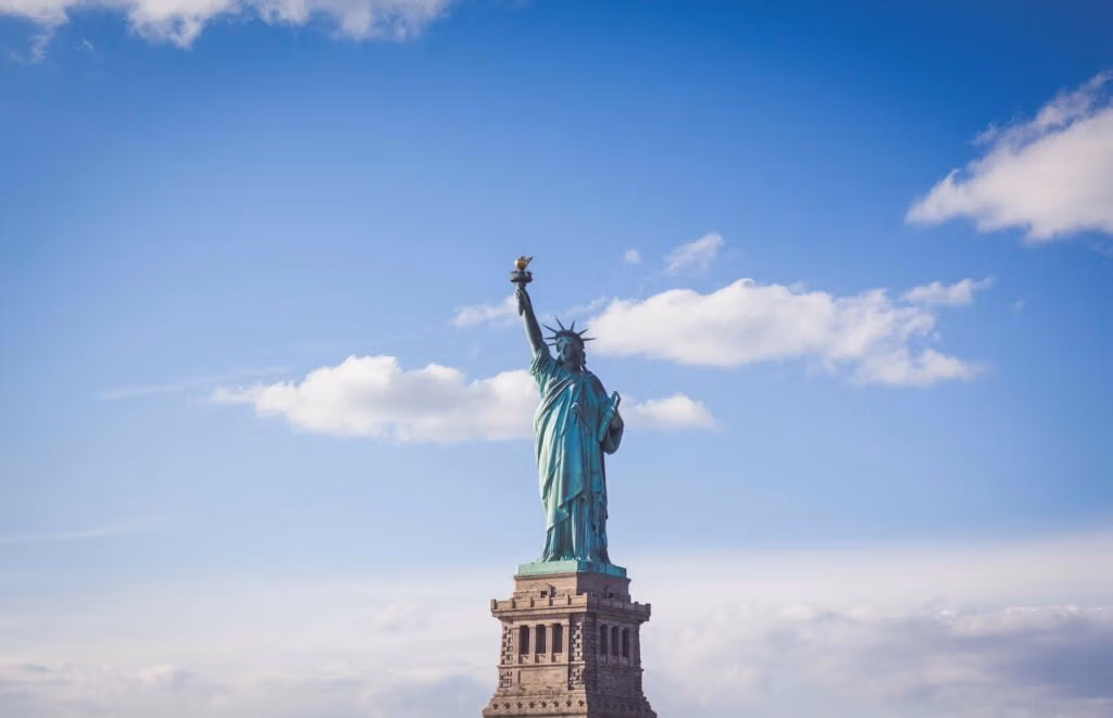 Statua della Libertà, New York sotto un cielo nuvoloso bianco e blu