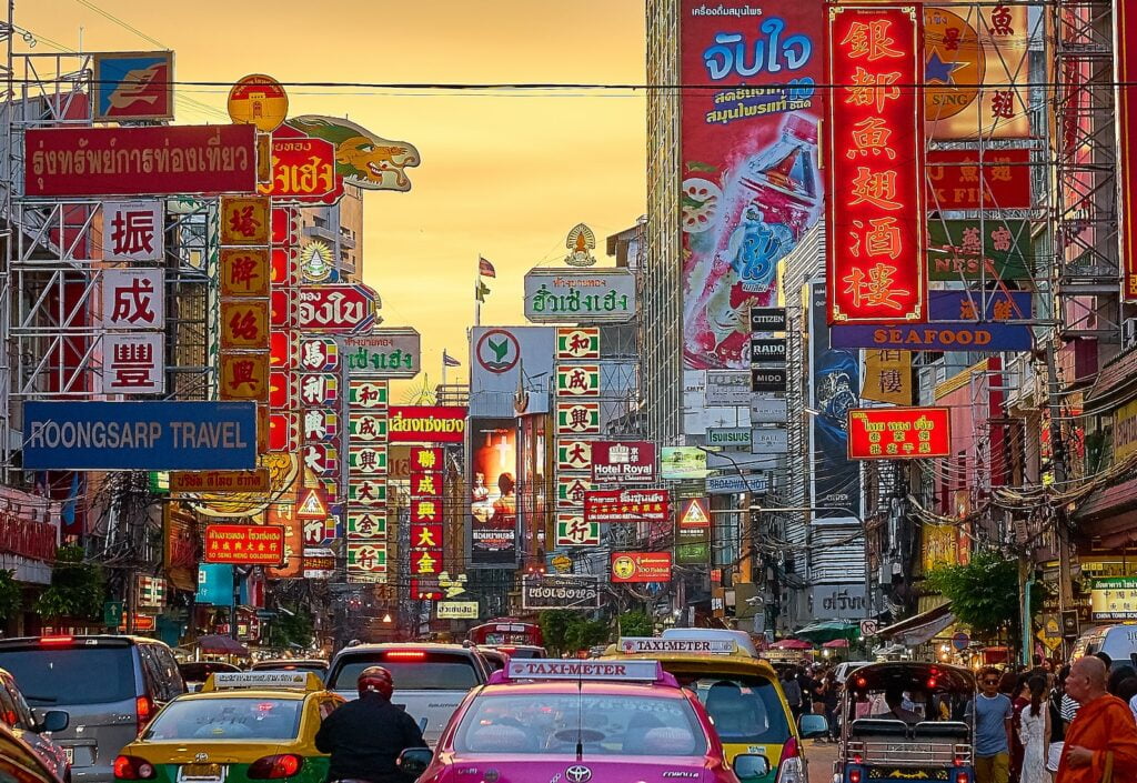 veicoli sulla strada tra gli edifici con segnaletica in caratteri Kanji durante l'ora d'oro