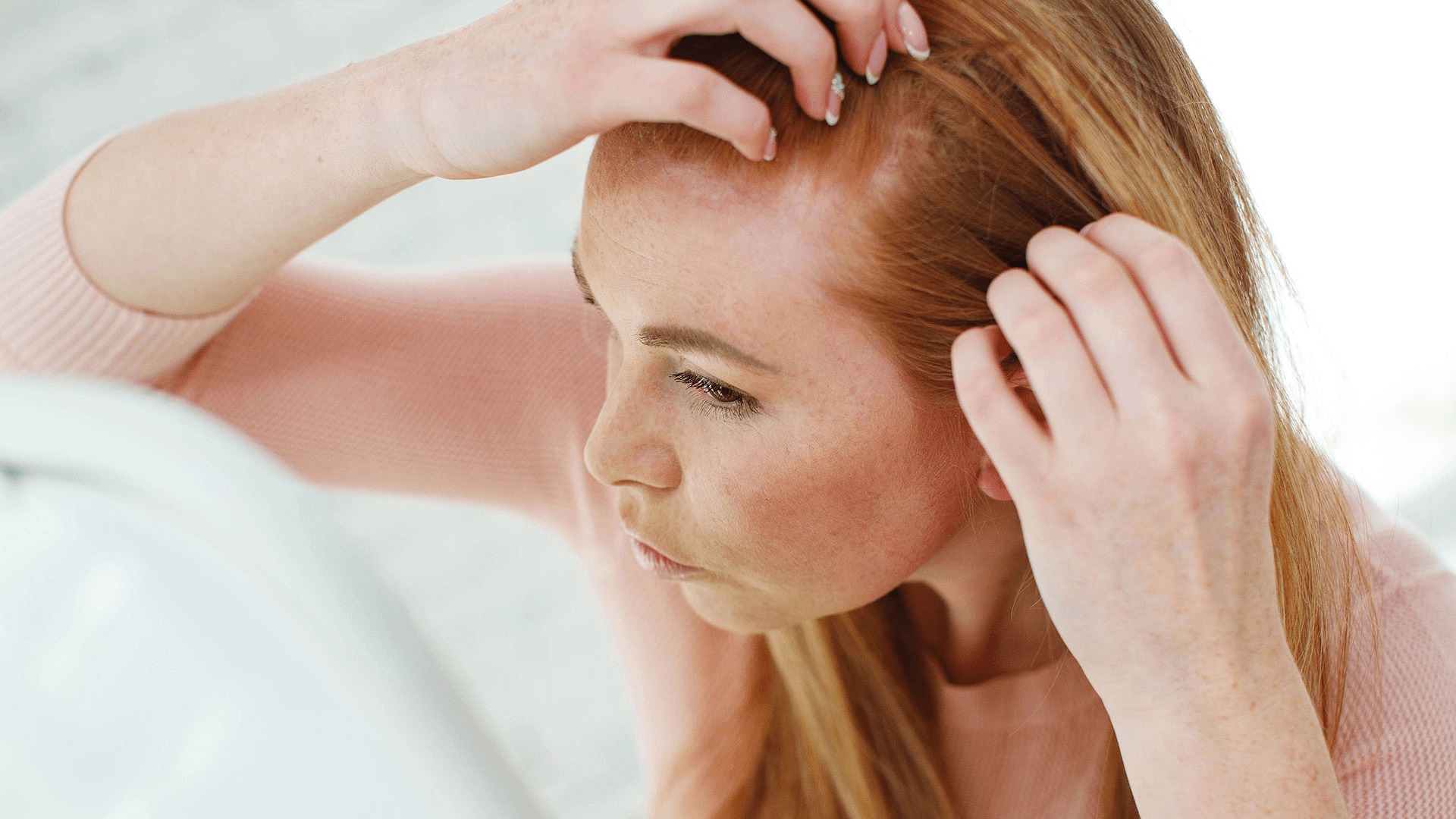 A woman with her hands in her hair, possibly expressing frustration or deep thought.