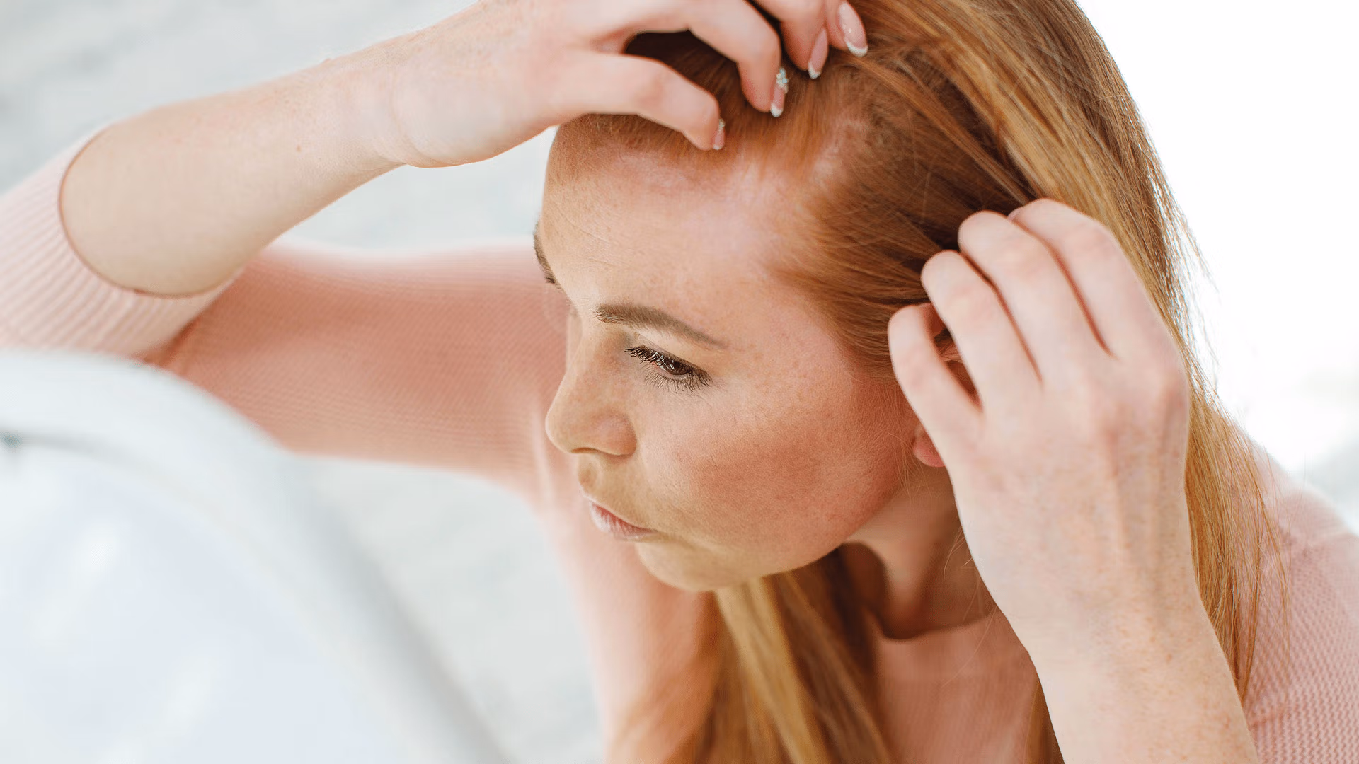 A woman with her hands in her hair, possibly expressing frustration or deep thought.