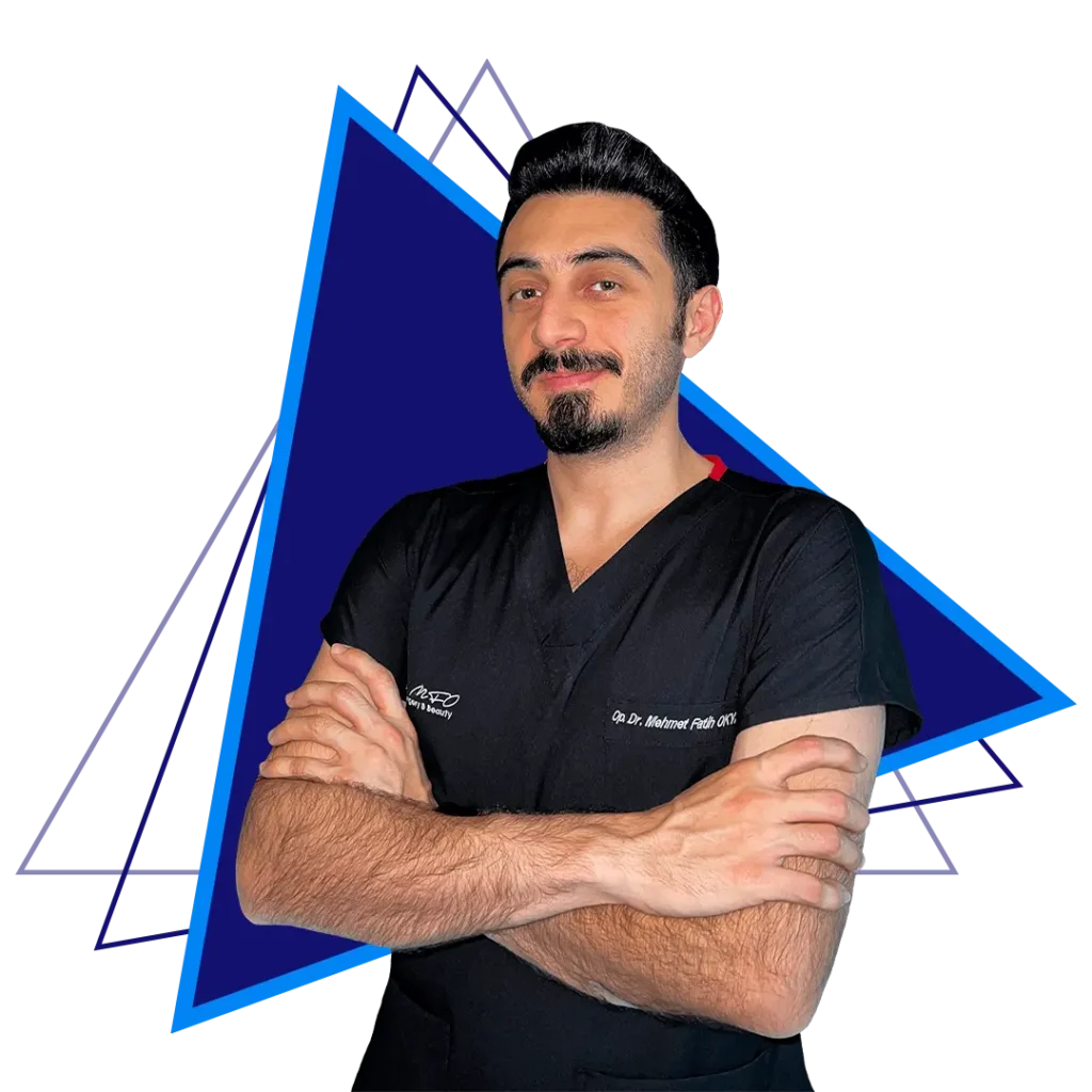 Ein professionelles Porträt von Dr. Mehmet Fatih Öztürk, einem plastischen Gesichtschirurgen. Er steht selbstbewusst mit verschränkten Armen da und trägt ein schwarzes OP-Oberteil vor einem blauen geometrischen Hintergrund.