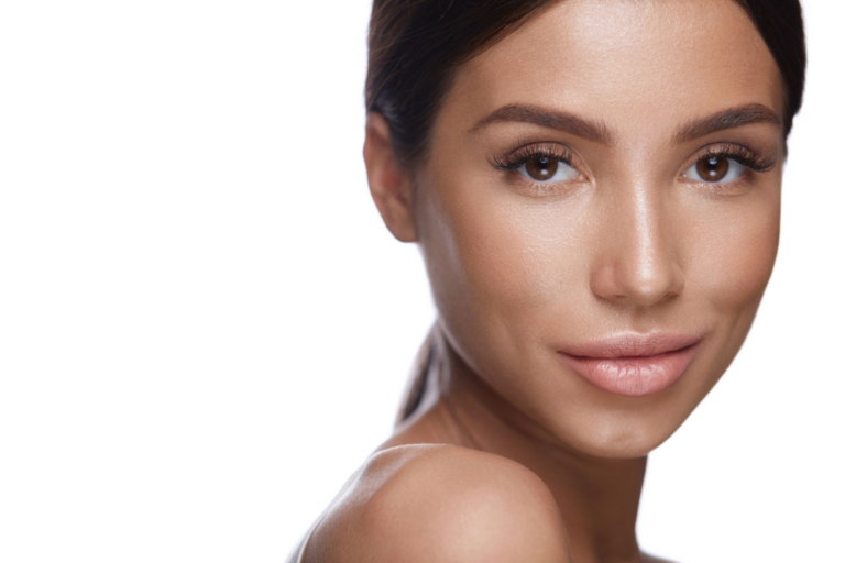 Un retrato en primer plano de una mujer con una piel suave y brillante, mirando directamente a la cámara con una expresión natural.