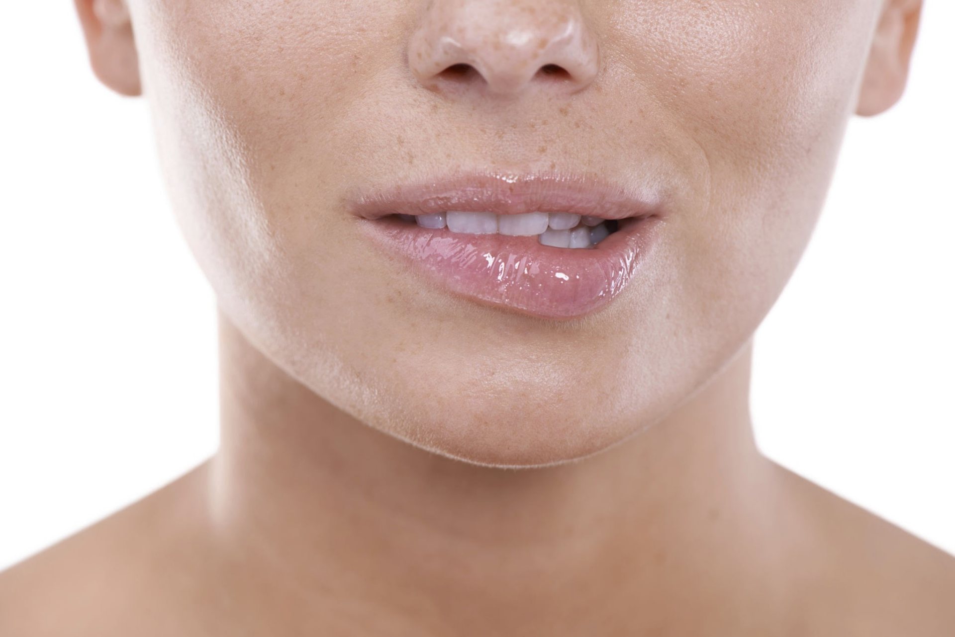 Крупный план нижней части лица человека с акцентом на губы и подбородок. Губы выглядят влажными и слегка блестящими, а кожа на подбородке и вокруг него гладкая, с несколькими видимыми порами. Фон однотонный и белый, что подчёркивает черты лица.
