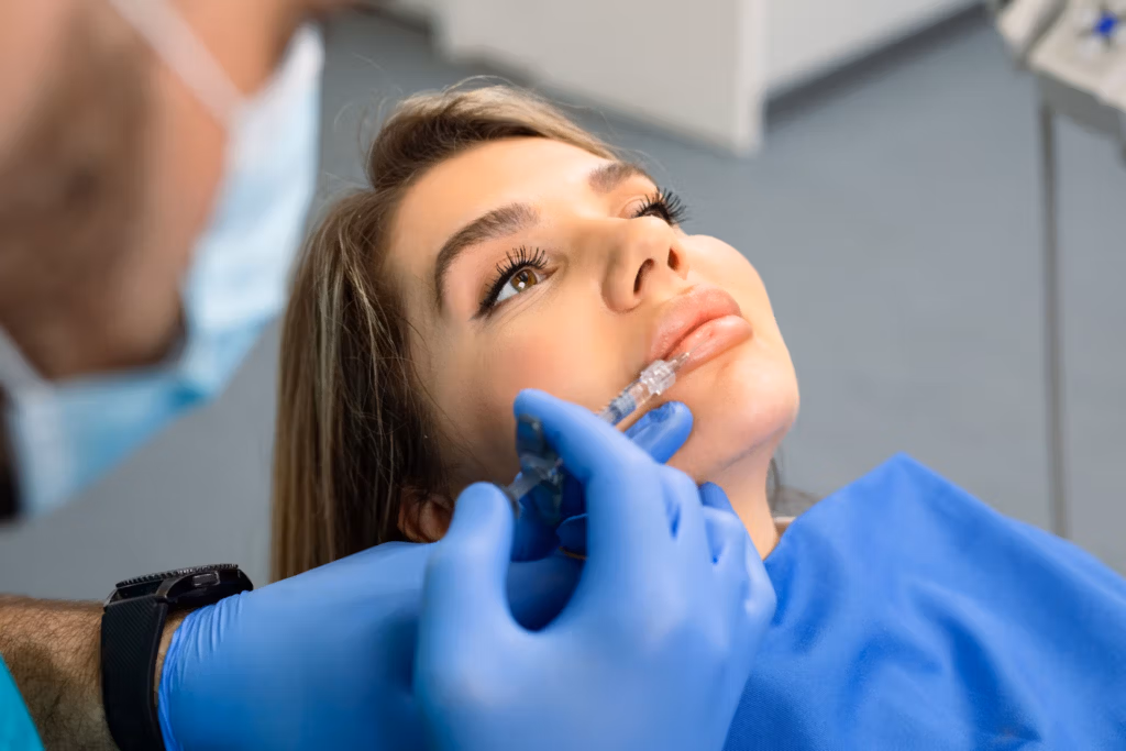 A dentist inserting a clear Invisalign aligner into a patient's mouth during a dental procedure.