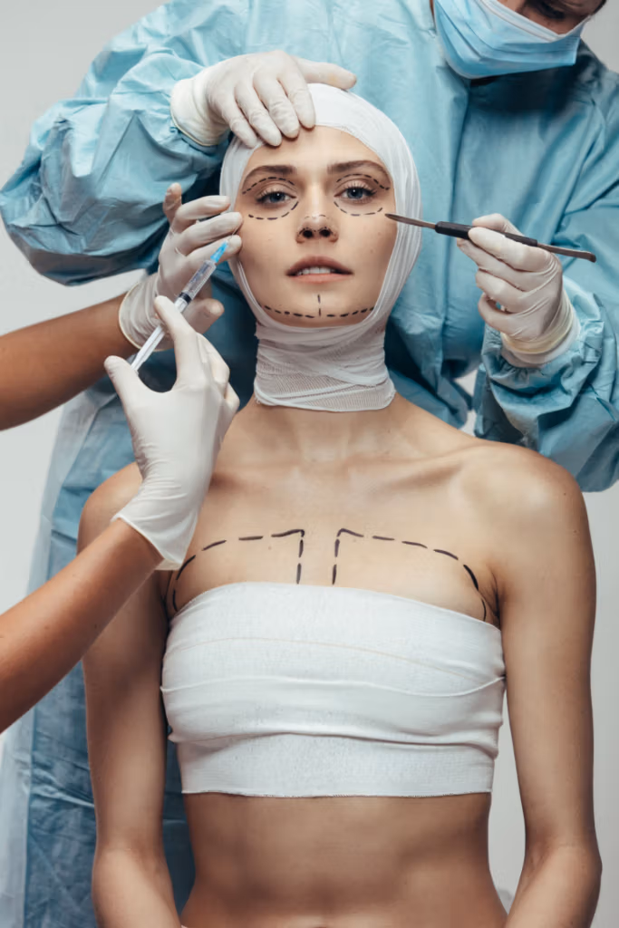 A woman undergoing plastic surgery with medical professionals making markings on her face and body.