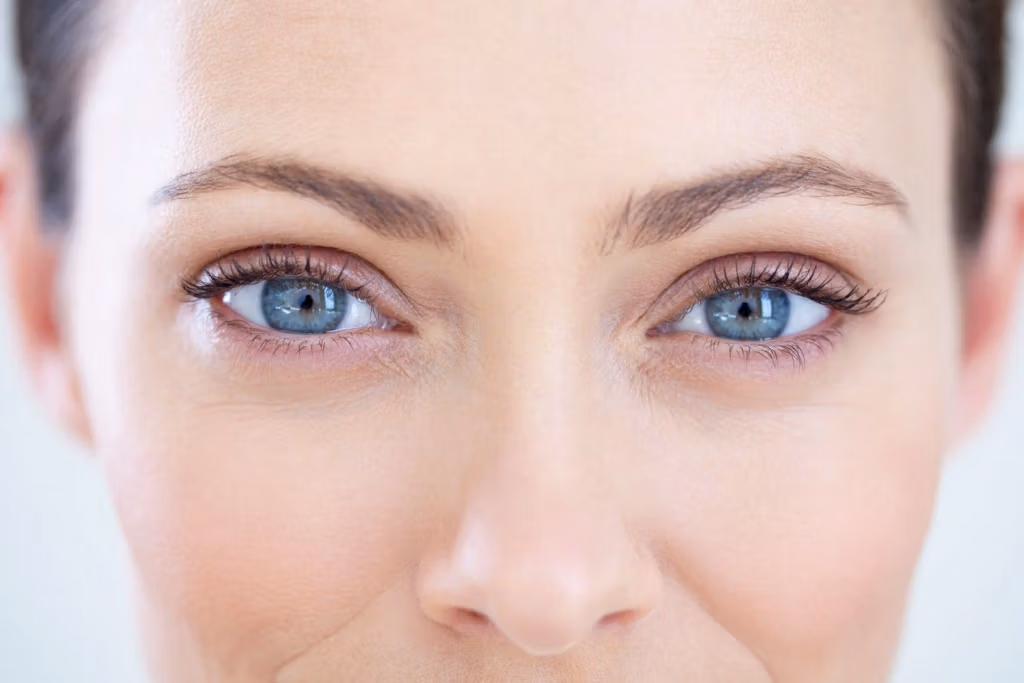 A close-up image of a person's face, focusing on the eyes and surrounding area. The person has light skin, blue eyes, and prominent eyebrows. The image highlights the facial features, including the nose and forehead.
