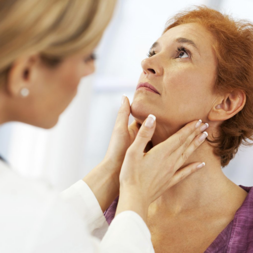 A medical professional examining a patient's neck, likely checking for signs of thyroid issues or other medical conditions.