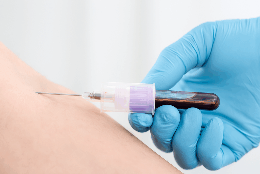 Une main gantée de bleu tient une seringue dont l'aiguille est pointée vers le bras d'une personne, probablement pour une injection.