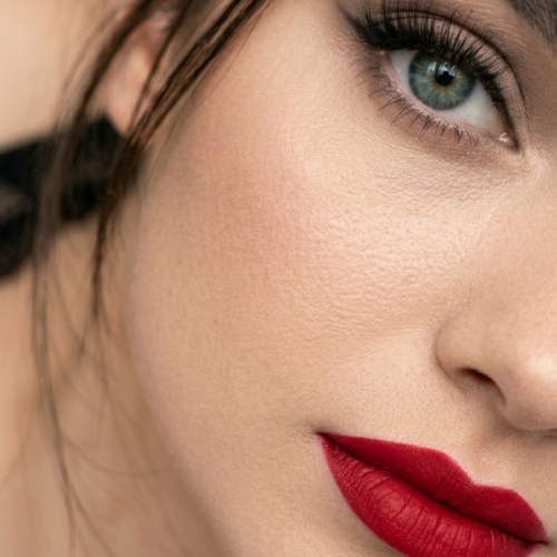 Portrait en gros plan d'une femme aux yeux verts et au rouge à lèvres rouge vif.