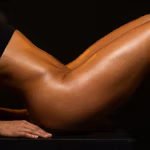 Nahaufnahme des durchtrainierten Oberkörpers, Bauches und der Beine einer sportlichen Frau, die ihre athletische Figur vor einem dunklen Hintergrund hervorhebt.