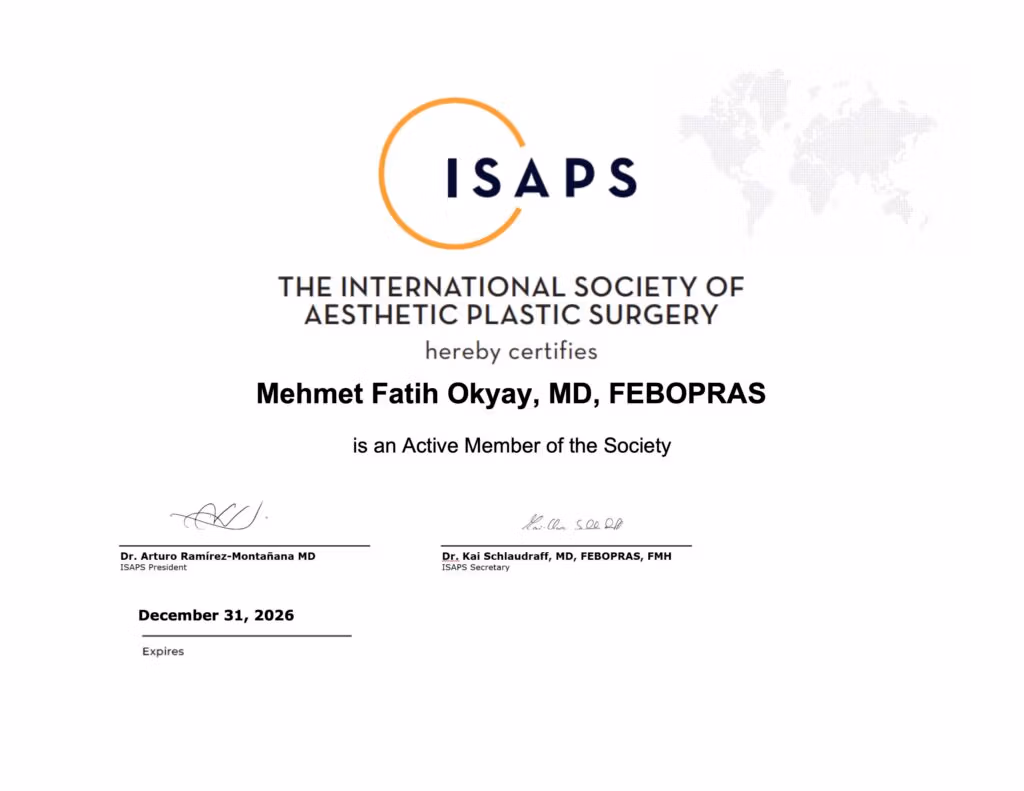 Uluslararası Estetik Plastik Cerrahi Derneği'nin (ISAPS) resmi üyelik belgesi, derneğin logosunu ve dünya haritası grafiğini içermektedir. Bu belge, Mehmet Fatih Okyay, MD, FEBOPRAS'ın Derneğin Aktif Üyesi olduğunu, ISAPS Başkanı Dr. Arturo Ramírez-Montañana ve Sekreter Dr. Kai Schlaudraff tarafından imzalandığını ve 31 Aralık 2026 tarihinde sona ereceğini onaylamaktadır.